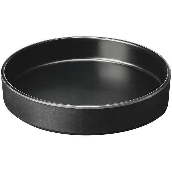 A black round Cal-Mil melamine plate with a raised rim.