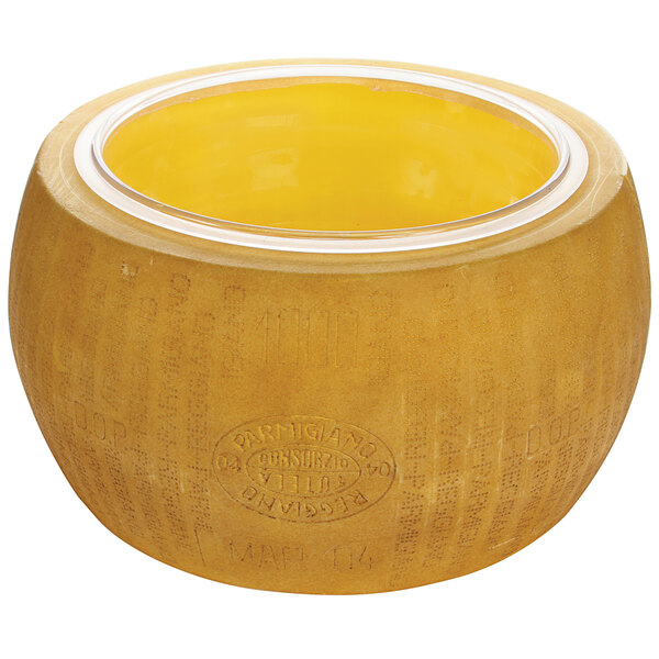 A yellow bowl with a clear lid containing a replica of Parmesan cheese with yellow wax on top.