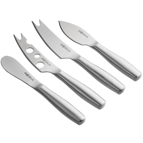A close-up of several stainless steel Boska Copenhagen cheese knives with handles.