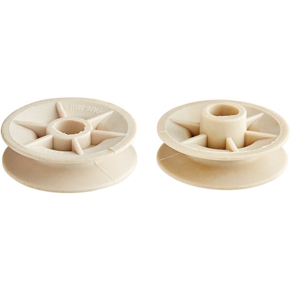 Two white plastic pulleys with a white wheel.