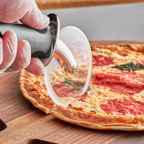A person using an OXO Good Grips pizza cutter to slice a pizza.