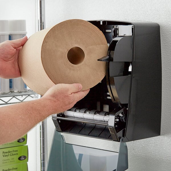 A person holding a roll of Lavex natural kraft paper towels.