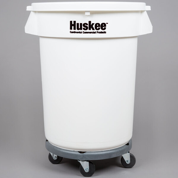 A white plastic container with wheels and a flat white lid with "Huskee" on it.