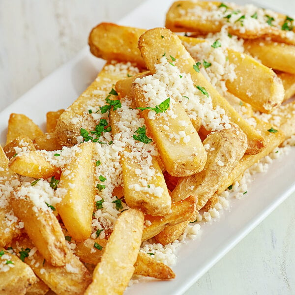 A plate of french fries with cheese and Violife Just Like Parmesan grated cheese.