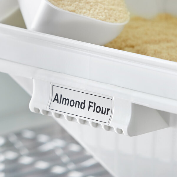 A white Baker's Mark ingredient bin label on a white container of almond flour.