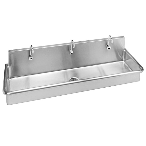 A Just Manufacturing stainless steel wall hung surgeon scrub sink with 3 sensor faucets.
