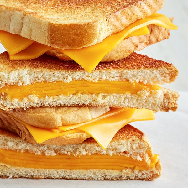 A stack of grilled cheese sandwiches with Violife Just Like Cheddar Vegan Cheese on top.