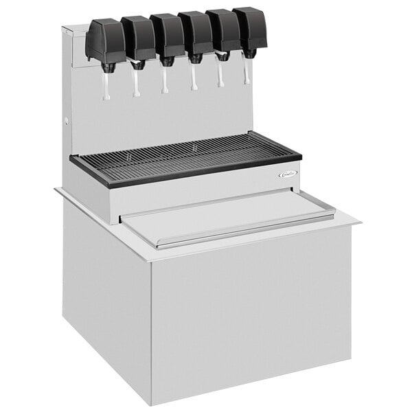 A Cornelius stainless steel soda dispenser with four black taps on a white countertop.