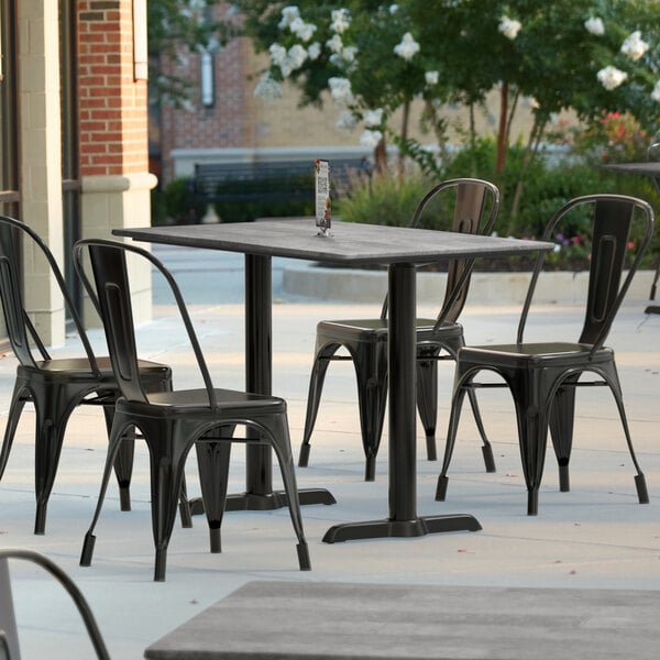 A Lancaster Table & Seating rectangular outdoor table with textured finish on a patio.