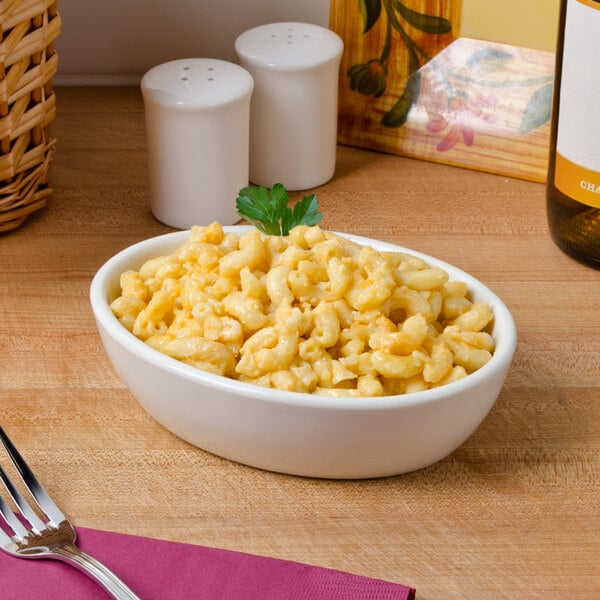 A Tuxton eggshell china baker bowl filled with macaroni and cheese on a table.