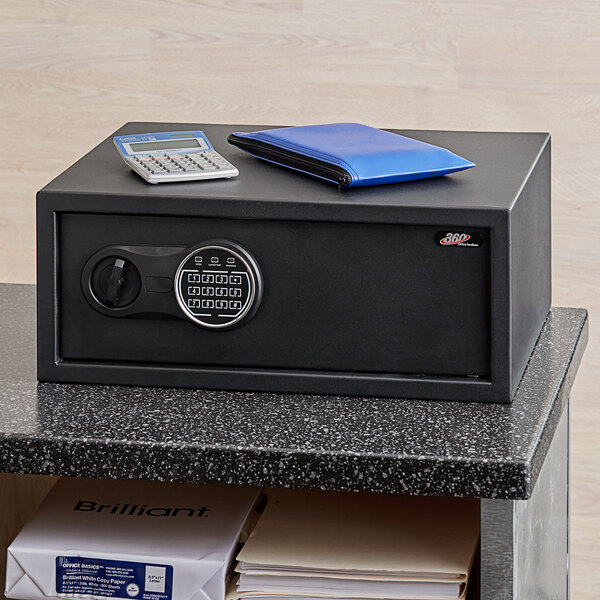 A black steel security safe with an electronic keypad lock and a calculator on top.