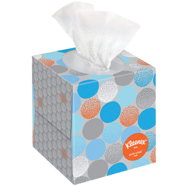 A Kleenex® tissue box with blue and orange dots on it.