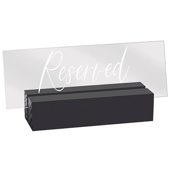 A black rectangular sign with white text that says "Reserved" on a clear plastic plate.