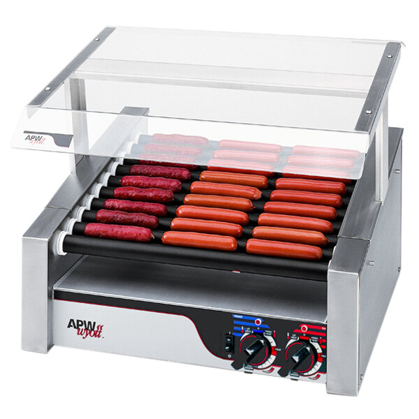 An APW Wyott hot dog roller with hot dogs cooking on it.