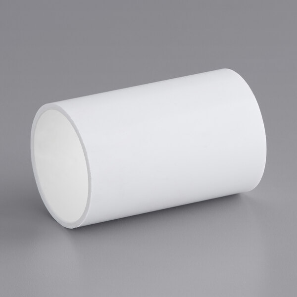 A white tube with a hole on a gray surface.