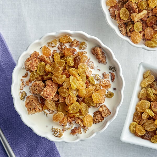 A bowl of cereal with milk and Golden Raisins.