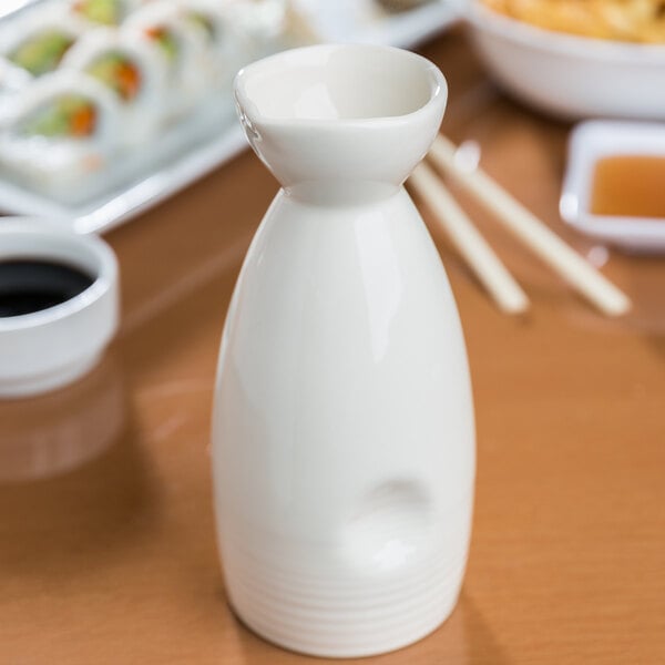 A close up of a white ceramic bottle.