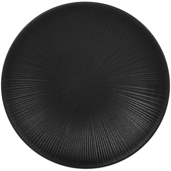 A close-up of a black plate with a circular textured pattern.
