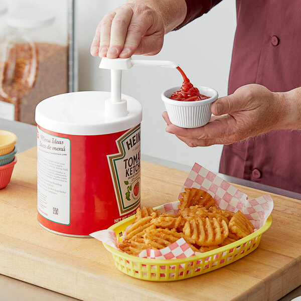 A person using a Choice snap-on adapter to pour ketchup into a container.