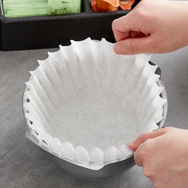 A hand holding a Fetco coffee filter.