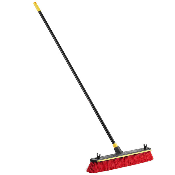 A Quickie Bulldozer 2-in-1 push broom with a black and red head and a yellow handle.