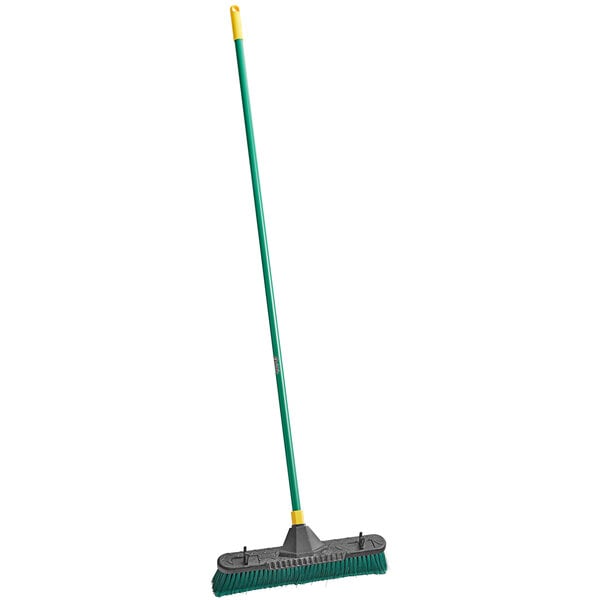 A green and yellow Quickie Bulldozer push broom.