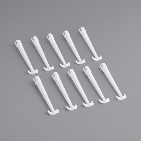 A group of white plastic agitator pegs on a gray surface.