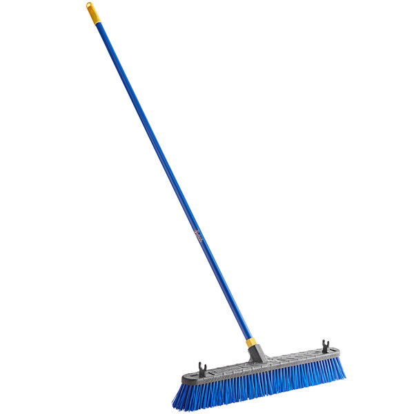 A Quickie Bulldozer blue and yellow push broom with a yellow handle.
