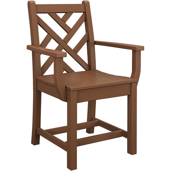 A brown POLYWOOD Chippendale dining arm chair with a cross design on the arms.