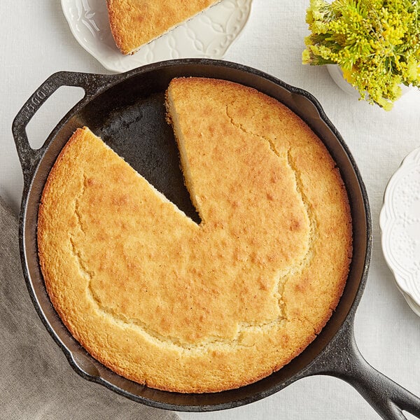 A skillet with a slice of cornbread made from White Lily Self-Rising Cornmeal Mix.