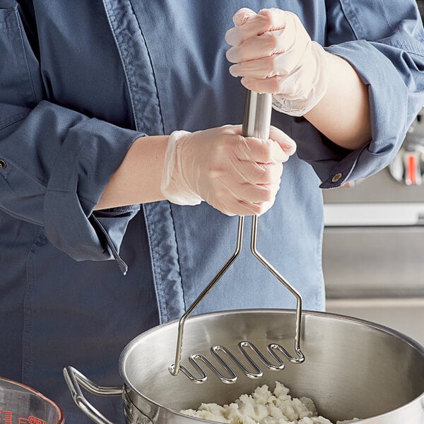 A person using a Tablecraft stainless steel masher to mash potatoes in a pot.