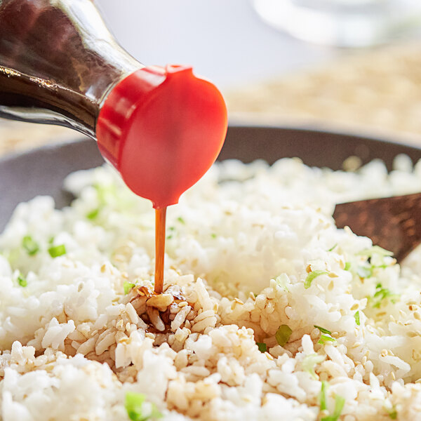 A person pouring Lee Kum Kee Seasoned Aromatic Vinegar into a bowl of rice.