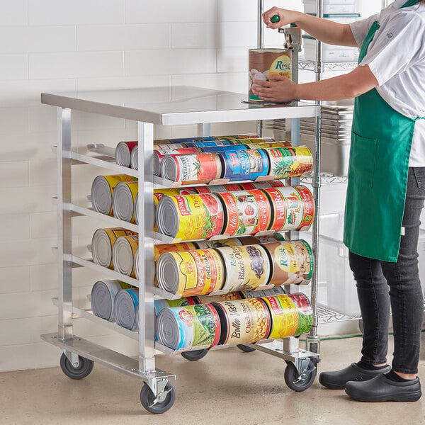 A woman using a Garde mobile can rack to store cans of food.