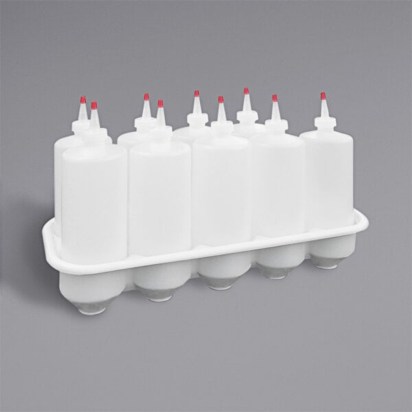 A white rectangular Prince Castle storage tray with a black border holding white bottles with red caps.