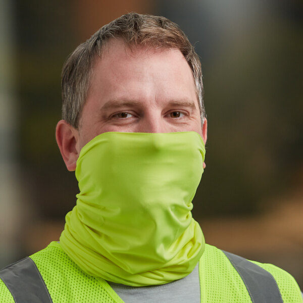 A man wearing a yellow vest and a lime green Ergodyne Chill-Its face/head covering.