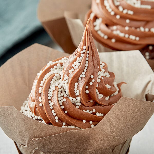 A chocolate cupcake with Ivory Nonpareils sprinkles.