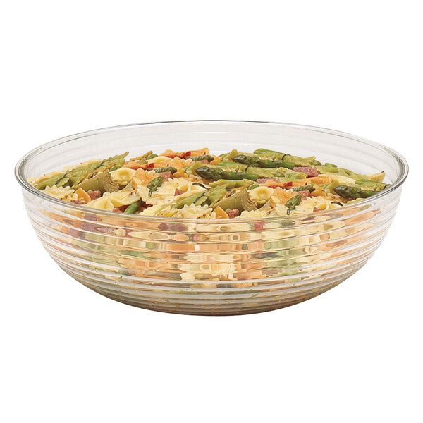 A clear Cambro ribbed bowl filled with pasta and asparagus.