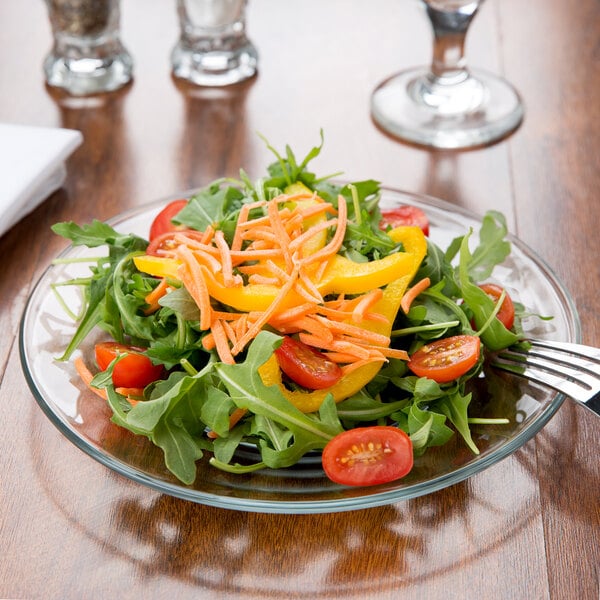 A salad with tomatoes, peppers, and cheese on an Anchor Hocking glass luncheon plate.