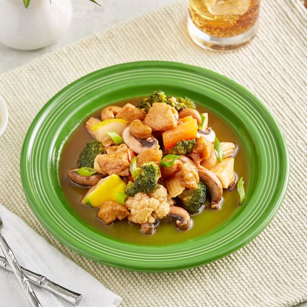 An Acopa Capri palm green stoneware plate with chicken and vegetables on it.