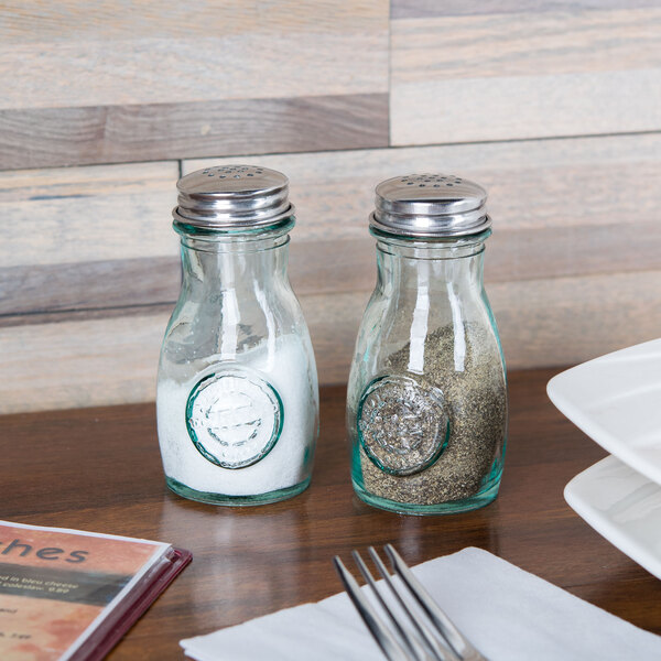A table set with a plate and Tablecraft recycled green glass salt and pepper shakers.