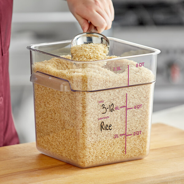 A person pouring rice into a Vigor food storage container.