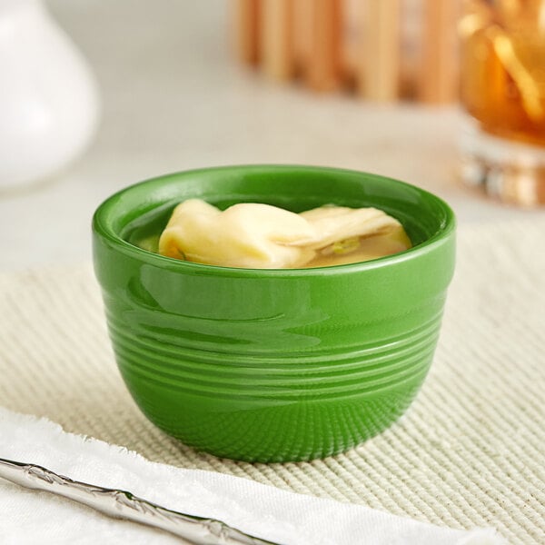 An Acopa Capri palm green stoneware bouillon cup filled with food.