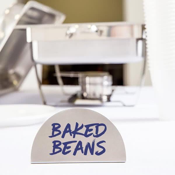 An American Metalcraft stainless steel menu card sign with blue text that says "Baked Beans" on a hotel buffet table.