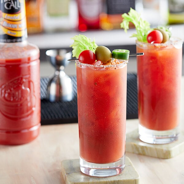 A table with glasses of Finest Call Loaded Bloody Marys with olives and tomatoes.