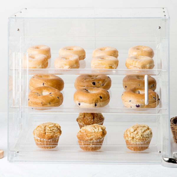 A Cal-Mil U-Build pastry display case on a counter with donuts and muffins inside.