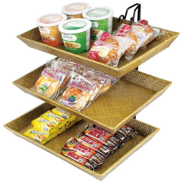 A Cal-Mil three tier wire merchandiser with bamboo trays holding food on a counter.