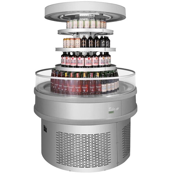 A Turbo Air stainless steel round island display case filled with a variety of beverages.