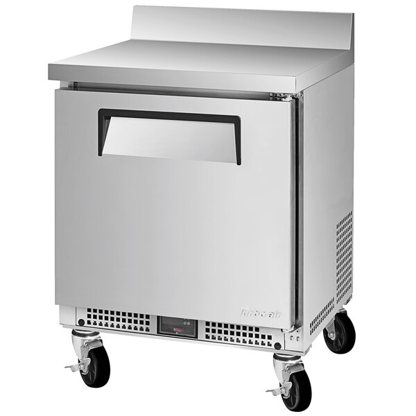 A silver stainless steel Turbo Air worktop refrigerator with wheels.