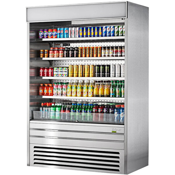 A Turbo Air stainless steel vertical air curtain display case full of beverages on shelves.