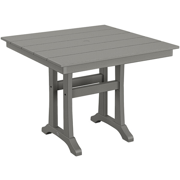 A POLYWOOD square grey dining table with trestle legs and a wooden top.